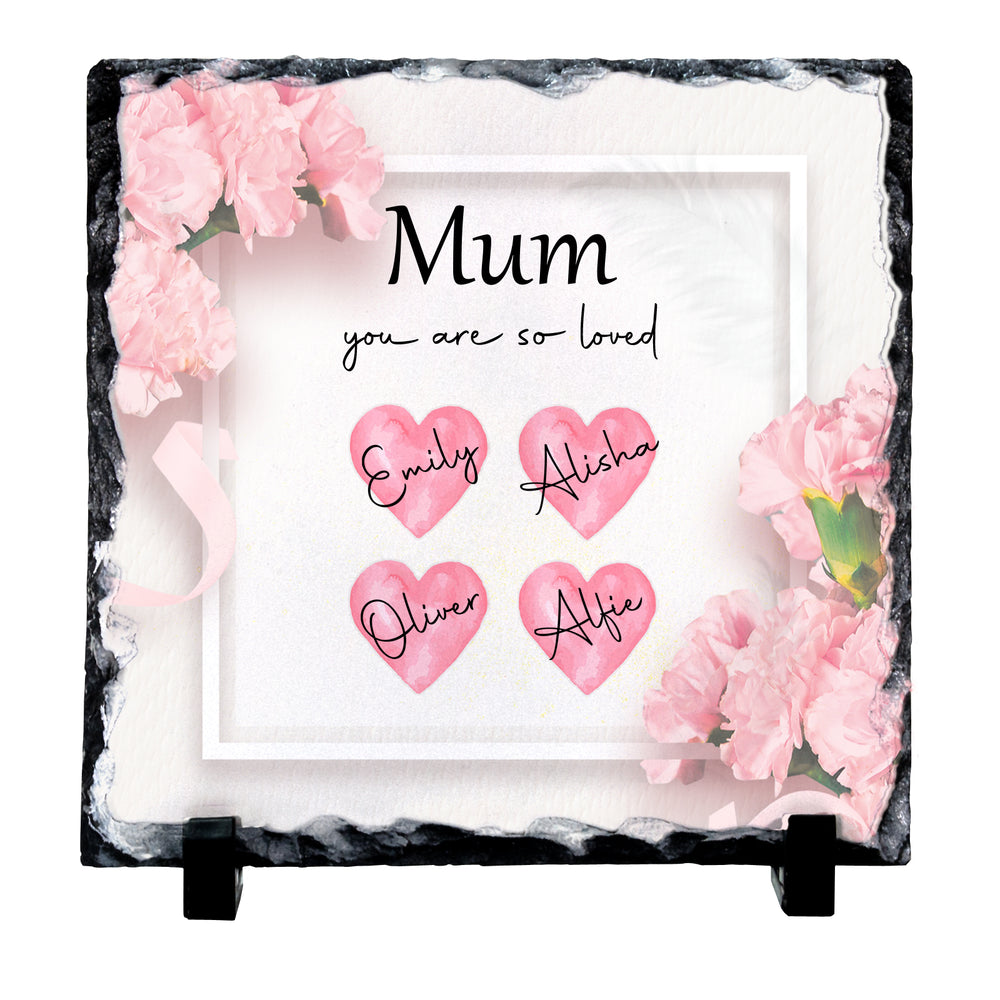 Personalized square slate plaque with a black stone border, pink carnation flowers, and four pink hearts with the names Emily, Alisha, Oliver, and Alfie. The center reads 'Mum you are so loved' in black text.