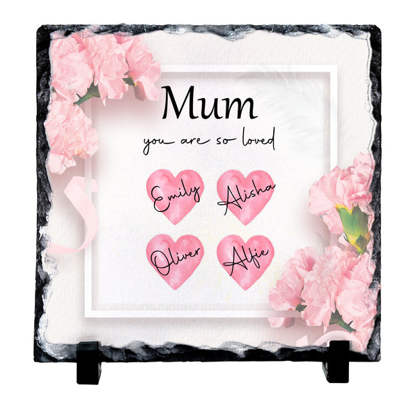 Personalized square slate plaque with a black stone border, pink carnation flowers, and four pink hearts with the names Emily, Alisha, Oliver, and Alfie. The center reads 'Mum you are so loved' in black text.