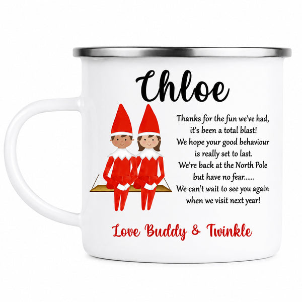 A white enamel-style mug with a silver rim, printed with a Christmas-themed message for 'Chloe' and two cartoon elves in red outfits. The mug reads, 'Thanks for the fun we've had, it's been a total blast! We hope your good behaviour is really set to last.