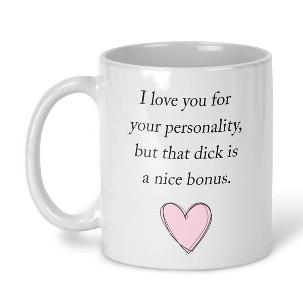 A white ceramic coffee mug with black printed text that reads 'I love you for your personality, but that dick is a nice bonus.' and a small pink heart illustration near the bottom, shown on a white background.
