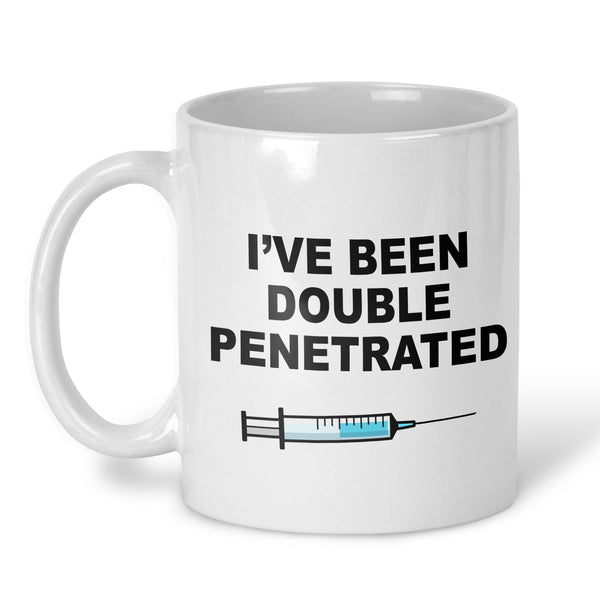 A white ceramic mug with the text 'I'VE BEEN DOUBLE PENETRATED' in bold black letters and a syringe graphic below, shown on a clean white background.