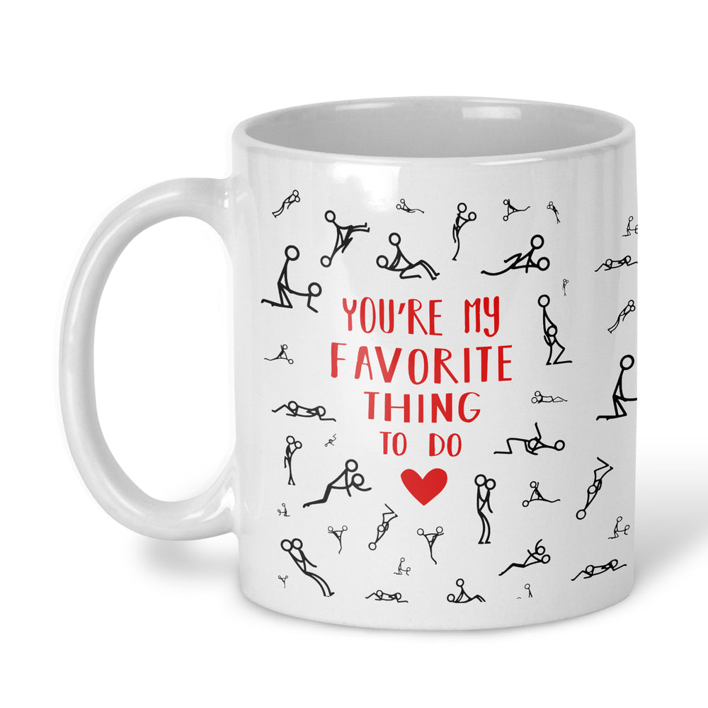 A white ceramic mug with a handle, decorated with black stick-figure drawings and the red text 'YOU'RE MY FAVORITE THING TO DO' with a red heart, on a white background.