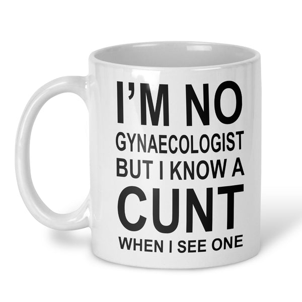 A white ceramic coffee mug with black printed text that reads 'I'M NO GYNAECOLOGIST BUT I KNOW A CUNT WHEN I SEE ONE' on a clean white background.