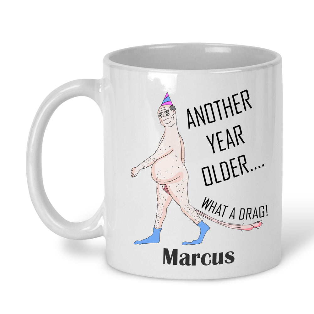 A white ceramic mug with a printed cartoon character and the text 'ANOTHER YEAR OLDER' personalised with name