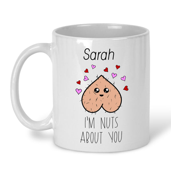 A white ceramic mug with a personalised message that reads 'I'm Nuts About You' accompanied by a graphic of a nut. Add any name